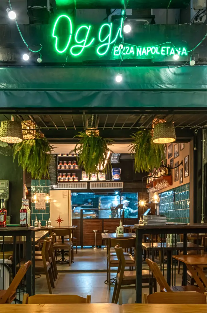 Fachada da Oggi Leblon com letreiro em neon verde